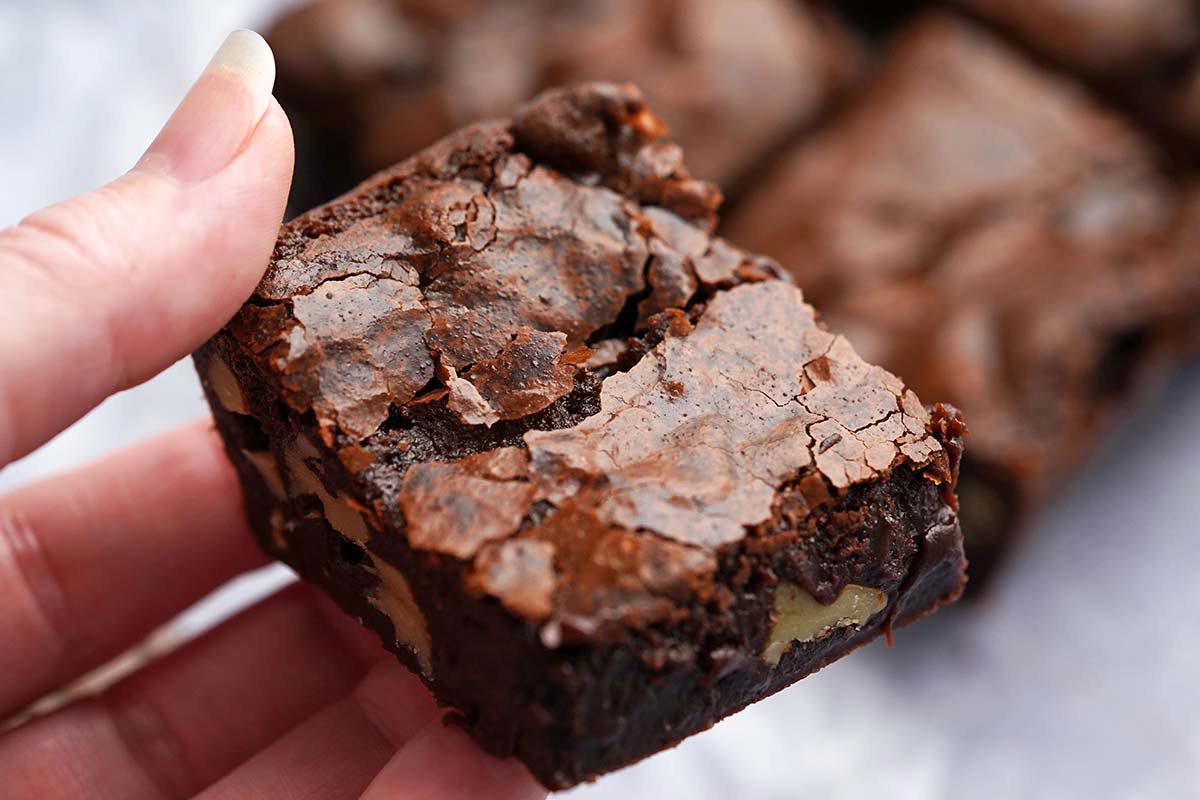 hand holding chewy chocolate brownie made with sourdough